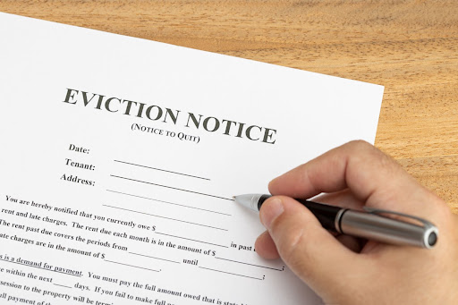 A person filling out a demand letter or eviction notice.